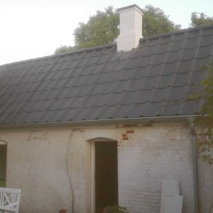 Hus i skovområde som er ved at blive renoveret, hvor tømrer som er medlem af Byg Garanti